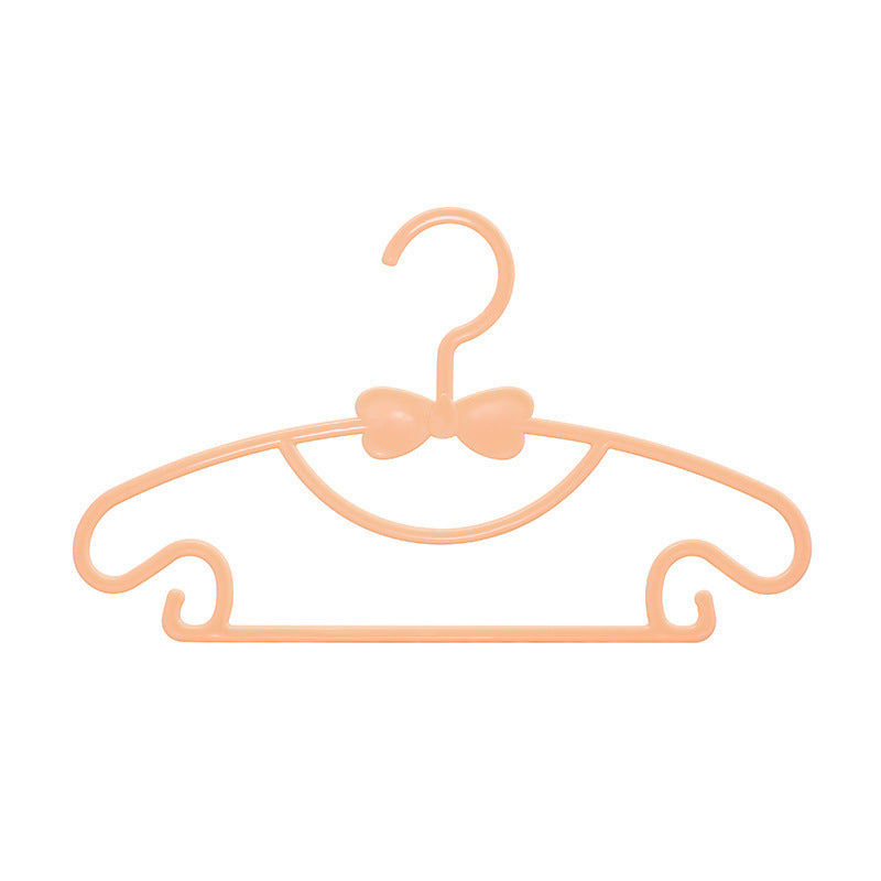 Orange children's clothes hanger with a bow detail on a white background