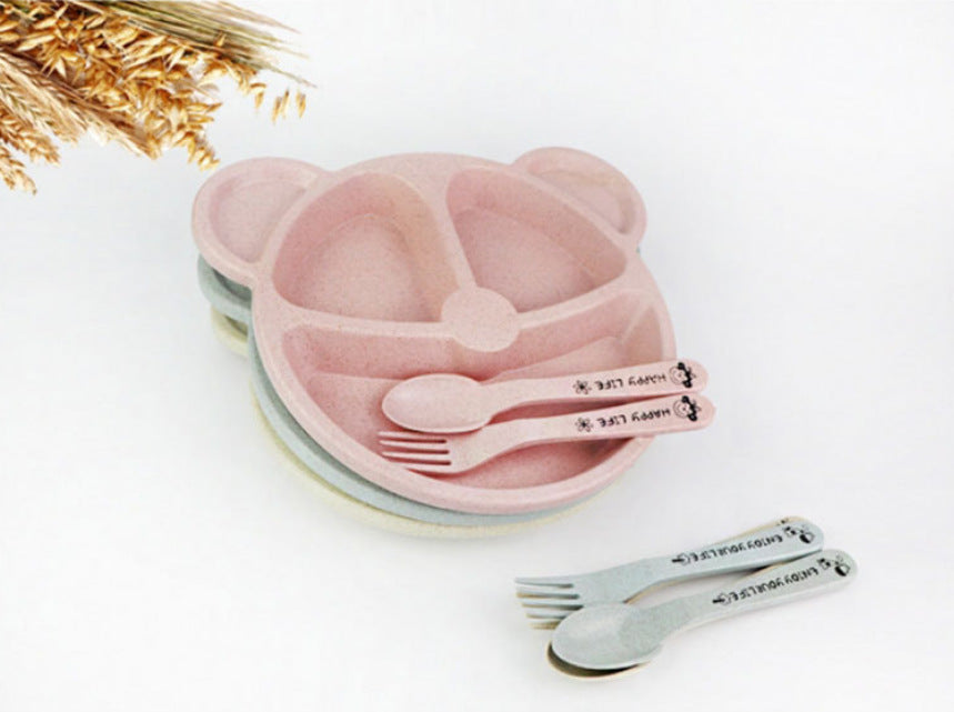 Pink bear-shaped divided plate holding citrus slices, with matching cutlery and stacked plates underneath