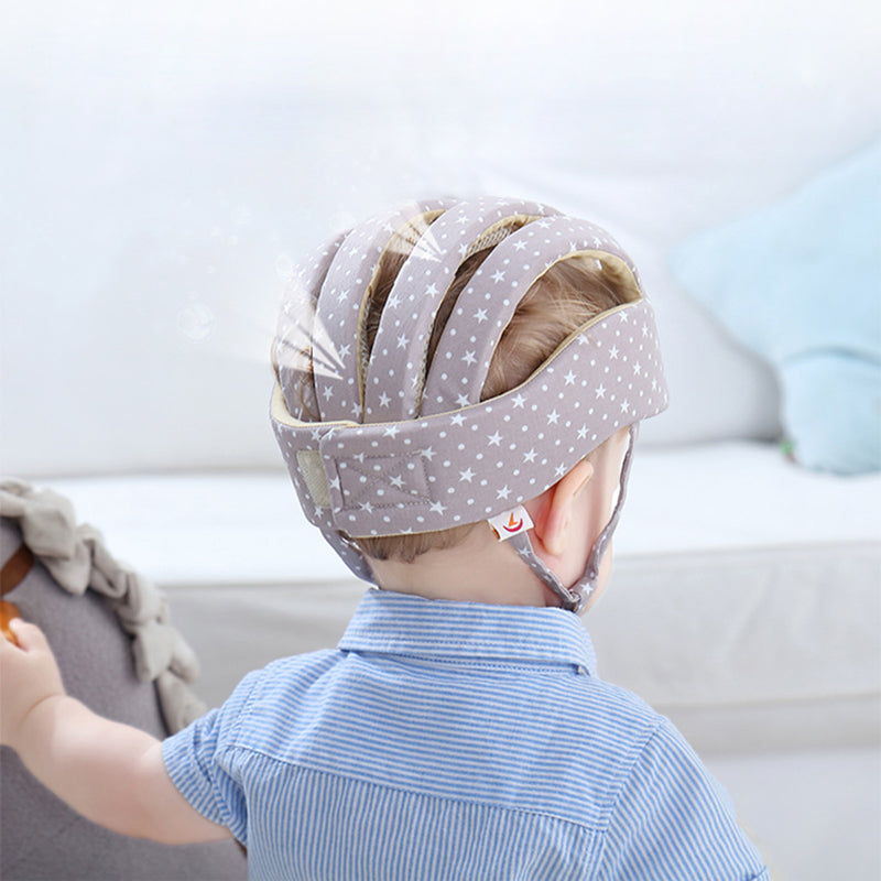 Rear view of a child wearing a gray star-patterned padded cap with open sections across the top